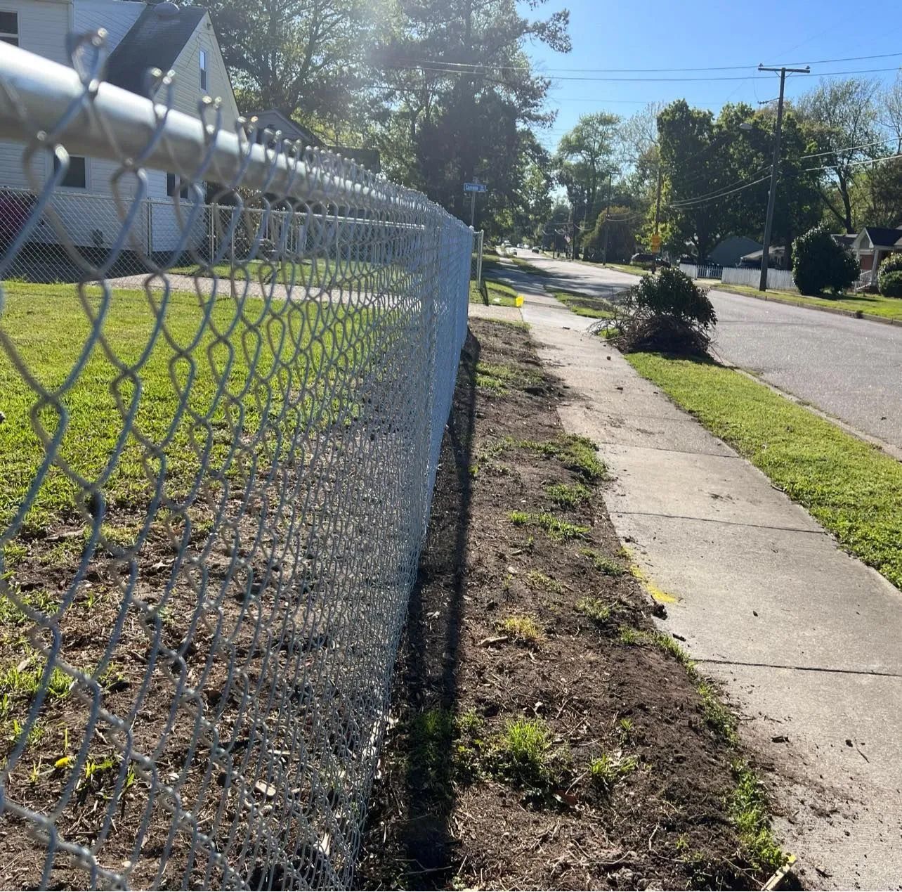 A chain link fence along the side of a road