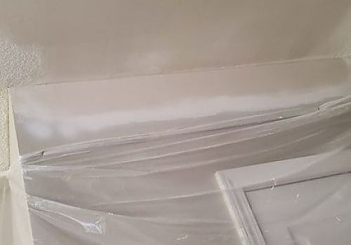 Stacked white wrapped items leaning against a wall in a room