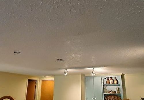 Living room ceiling with recessed lights, open door, and blue cabinet with decor