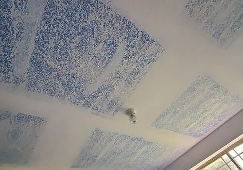 Blue textured ceiling with white beams and a small light fixture near the center