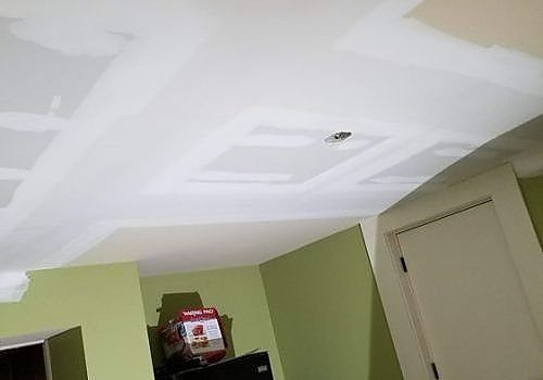 Ceiling with visible patchwork and a smoke detector in a room with pale green walls