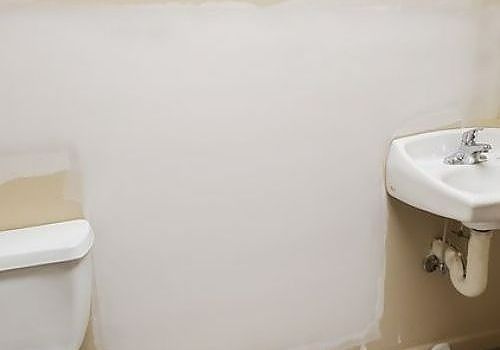 Small restroom with white wall and two wall-mounted sinks, one on each side.