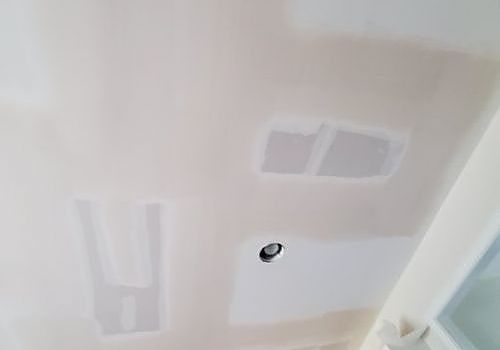 Ceiling with pink paint samples and a recessed light fixture