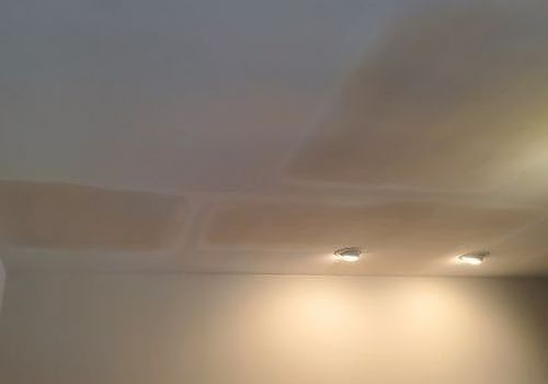 Ceiling with two recessed lights and warm wall lighting