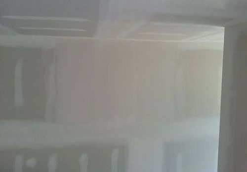 Empty room with unfinished drywall and a doorway on the right