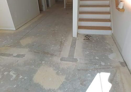 Unfinished interior hallway with concrete floor and stairs on the right