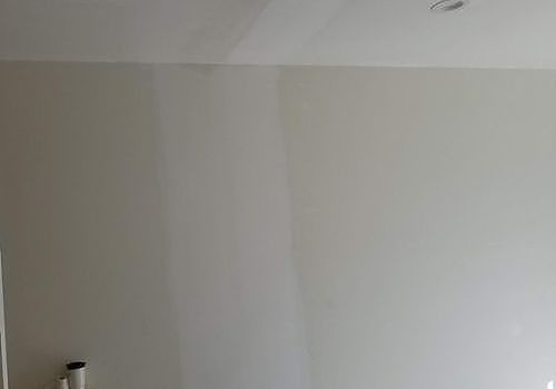 Bare white wall and ceiling corner in a sparsely furnished room