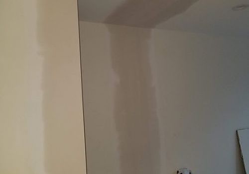 Bare white wall and ceiling corner in an empty room.