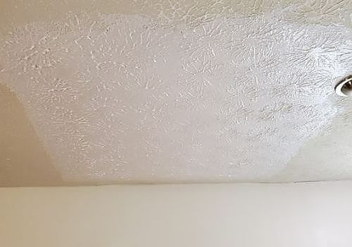 White textured ceiling with a small ceiling light in the top right corner.