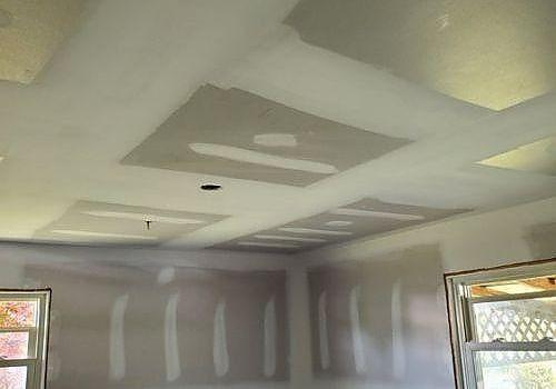 Partially finished room with taped drywall, a white ceiling, and window light