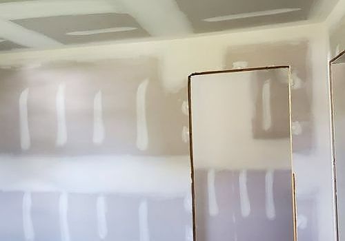 Unfinished drywall room with taped seams and a doorway opening