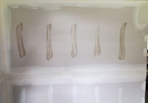 Five translucent, curved strips mounted in a row on a white wall or panel.