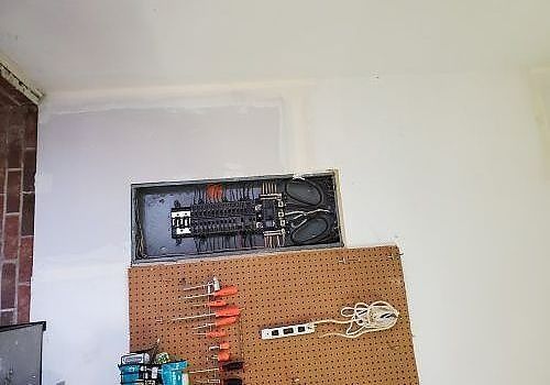 Wall-mounted tools and cables above a pegboard in a workshop corner