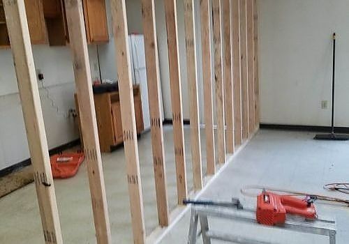Interior renovation with exposed wooden wall studs and tools in a room under construction