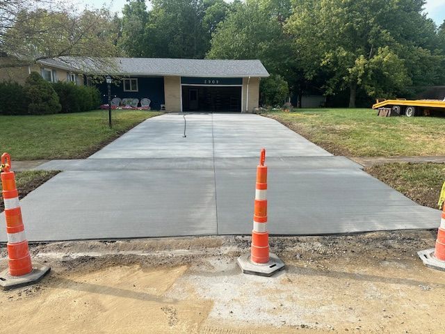 A concrete driveway is being built in front of a house