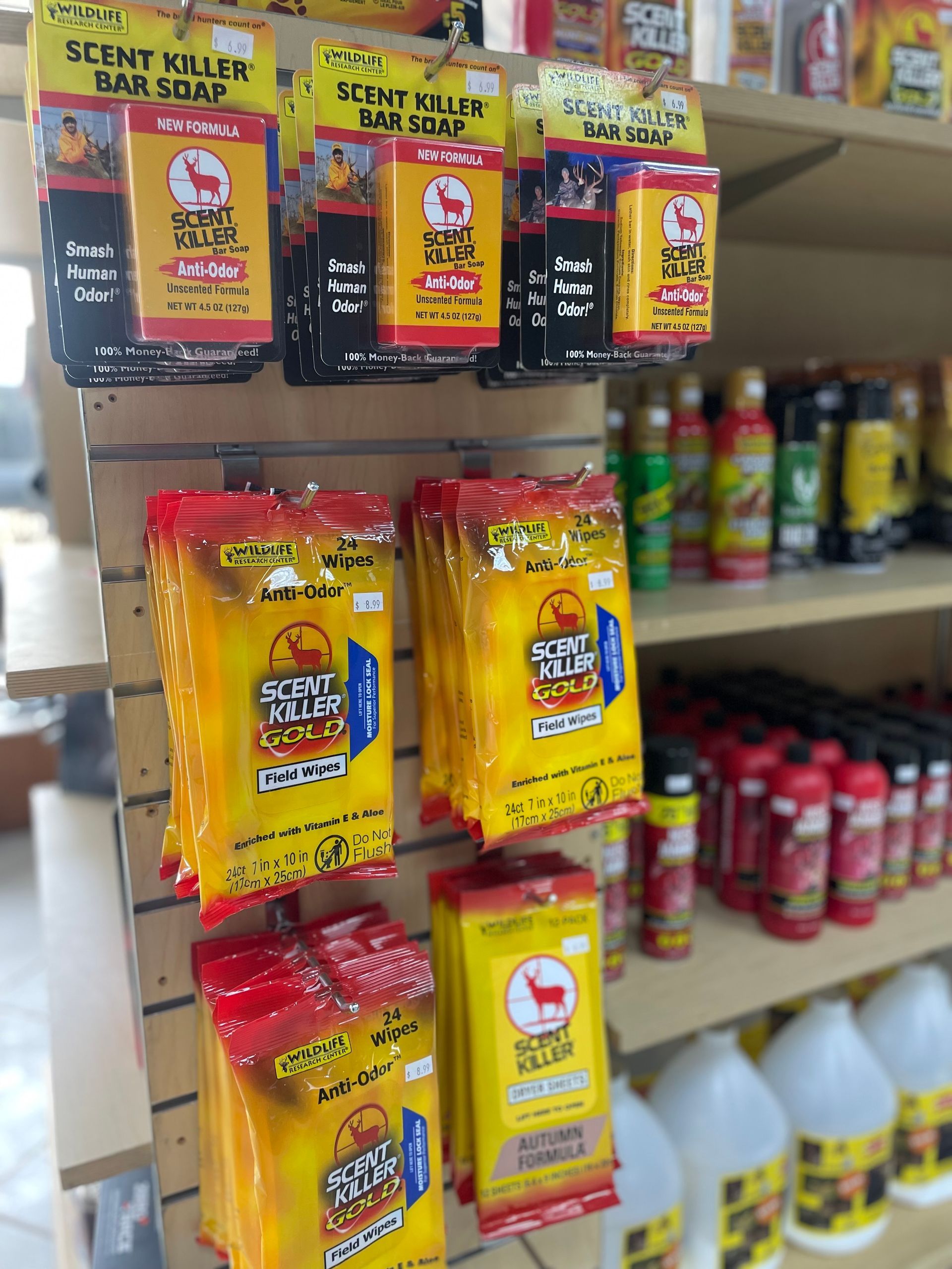 Hunting scent killer soap on display in a store. Yellow and black packaging, red accents, with various sizes.