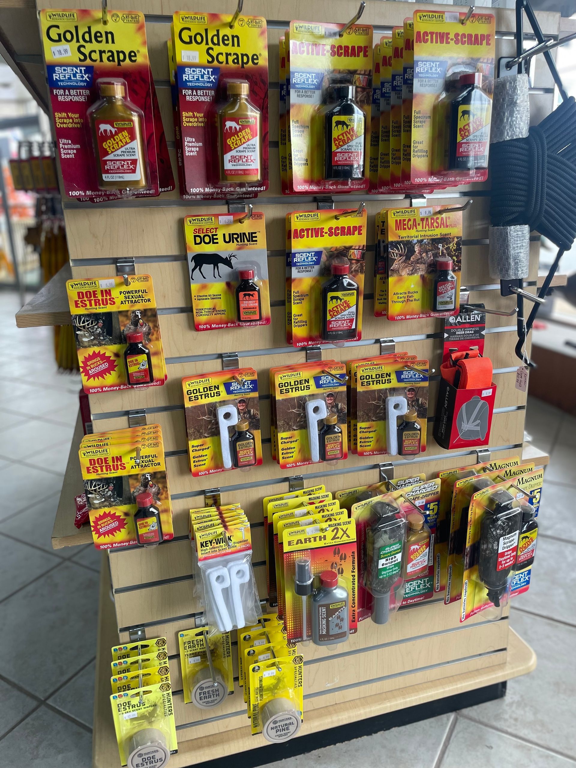 Display shelf with various packaged food items, primarily sauces, with yellow, red, and brown packaging.