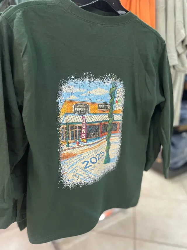 Dark green T-shirt with a colorful storefront graphic on the back hanging on a rack