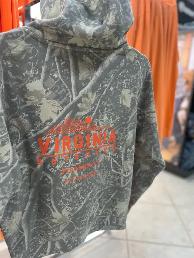 Camouflage hoodie with red “Virginia” text hanging in a store aisle