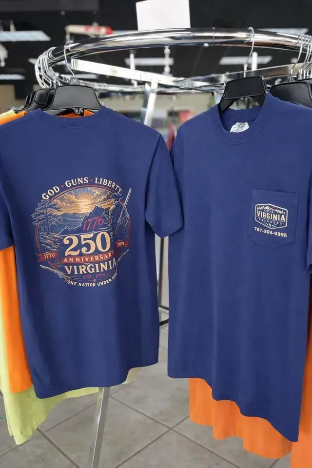 Two navy blue T-shirts hanging on a rack, one with a large “250 Virginia” graphic