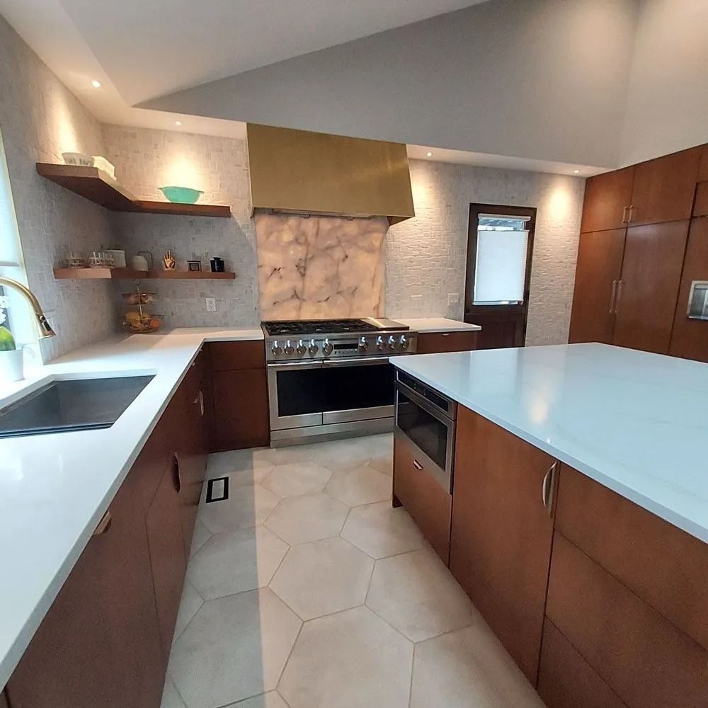 Modern kitchen with brown cabinets, white countertops, stainless steel appliances, and a central island.