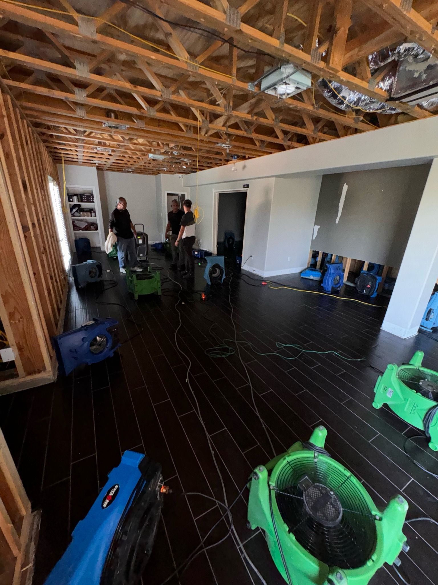 A group of people are standing in a room with a lot of fans.