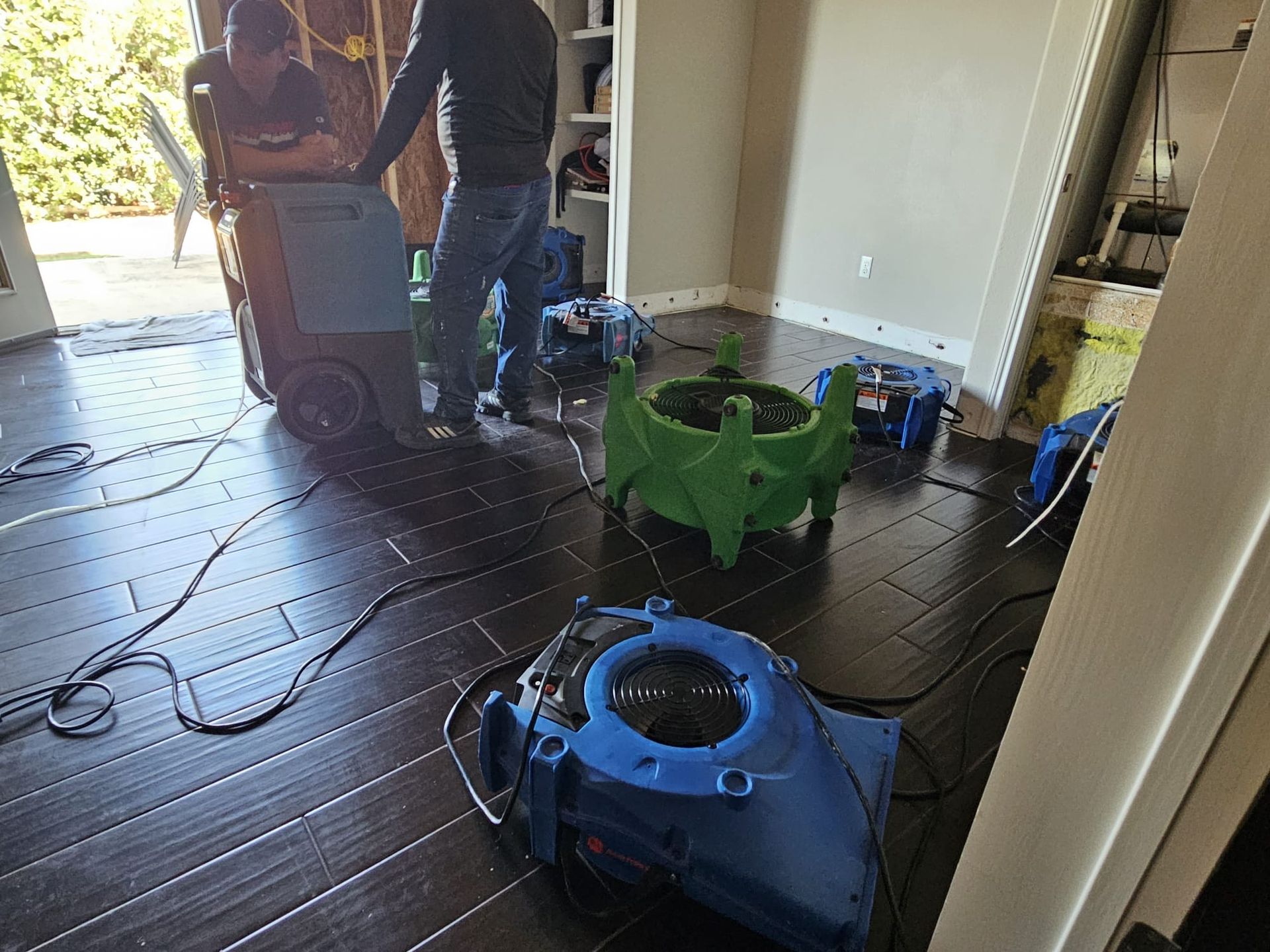 A man is standing in a room with a vacuum cleaner on the floor.