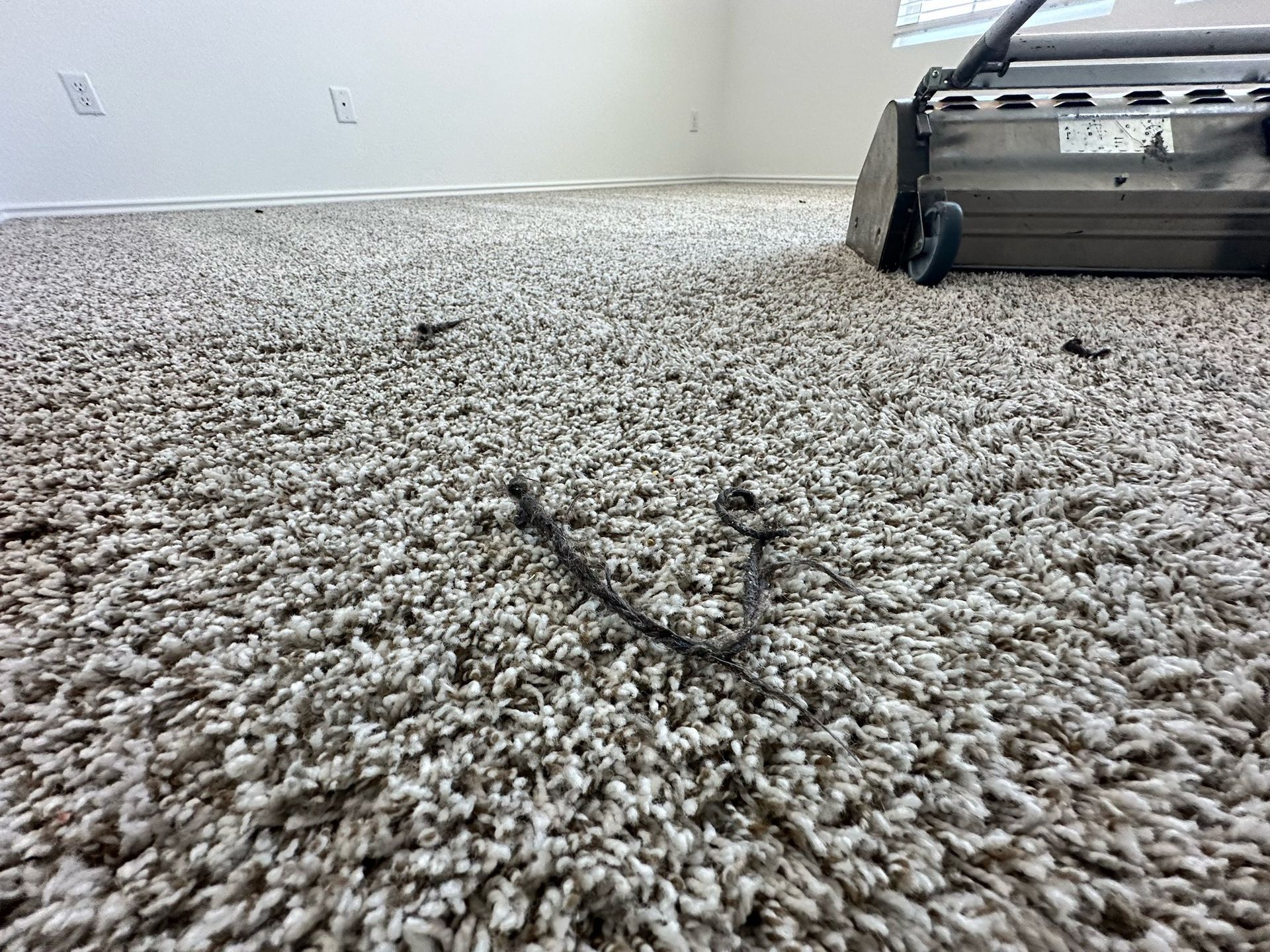 A vacuum cleaner is cleaning a carpet in a room.