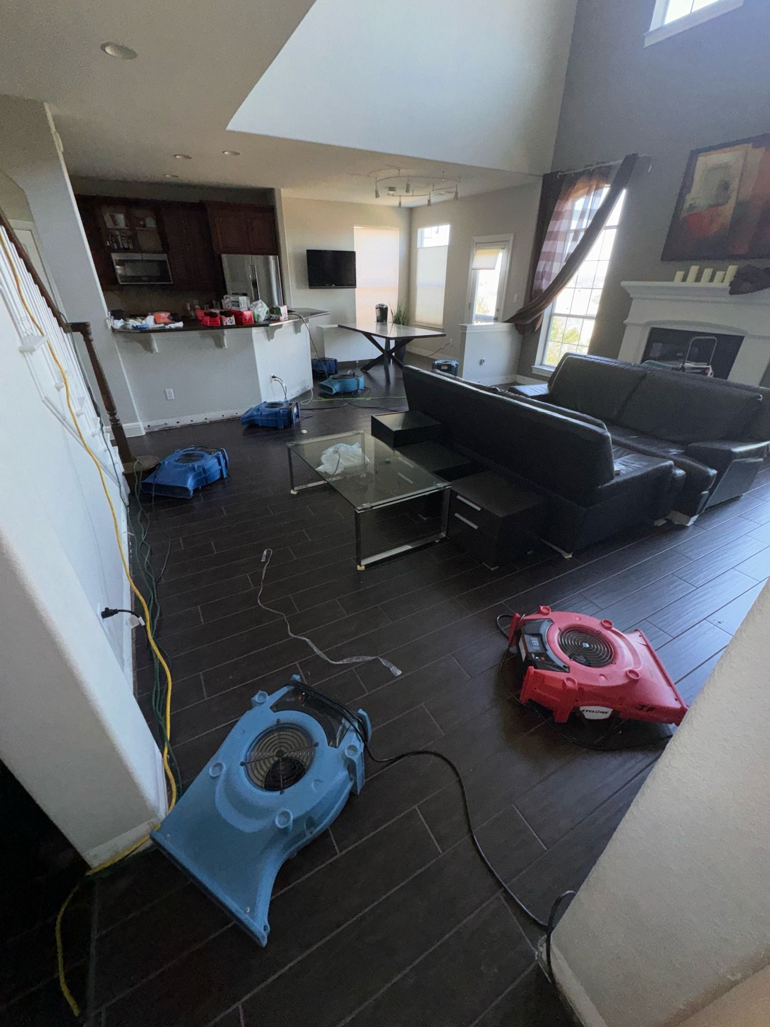 A living room filled with furniture and a vacuum cleaner on the floor.