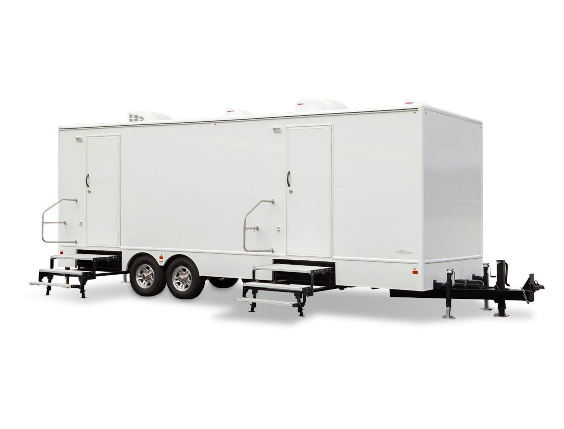A portable bathroom with a sink , toilets and a mirror