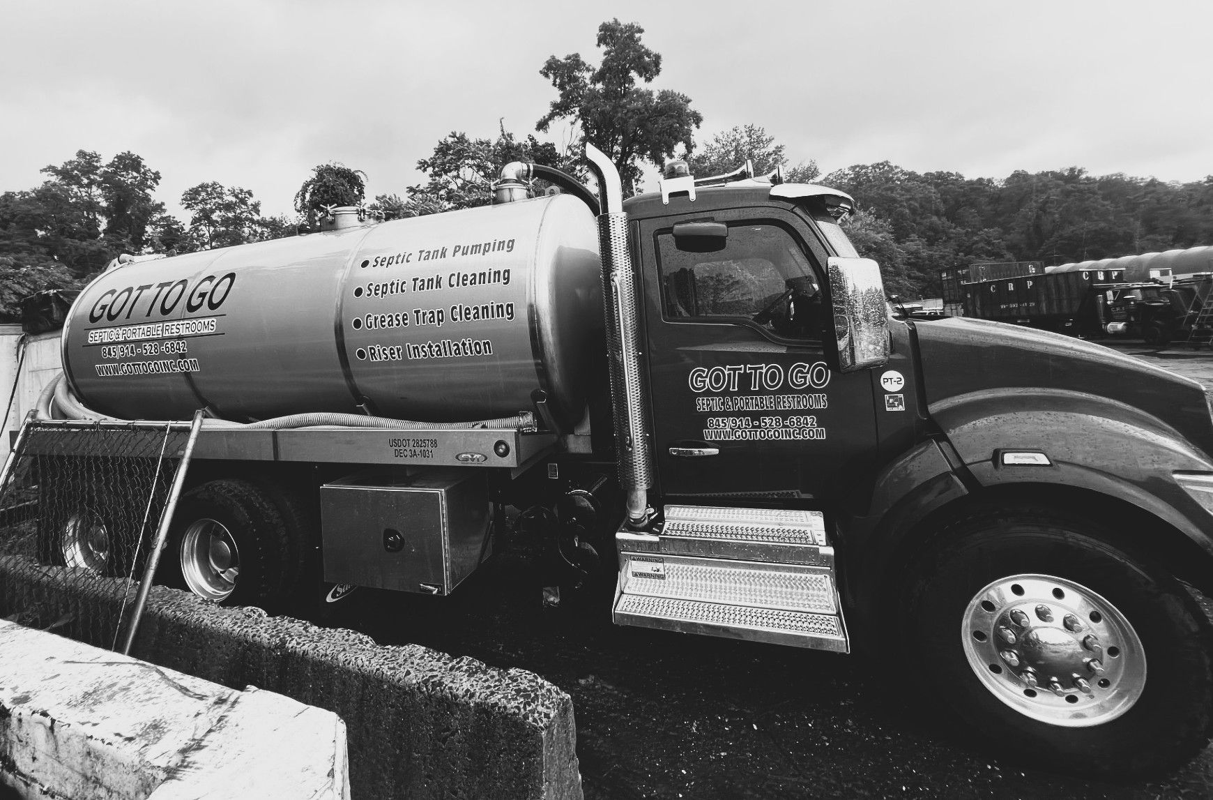Septic tank truck in grayscale.