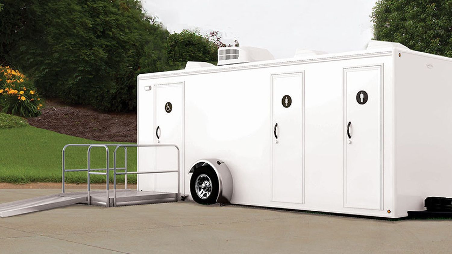 A white luxury portable restroom trailer with a ramp attached to it