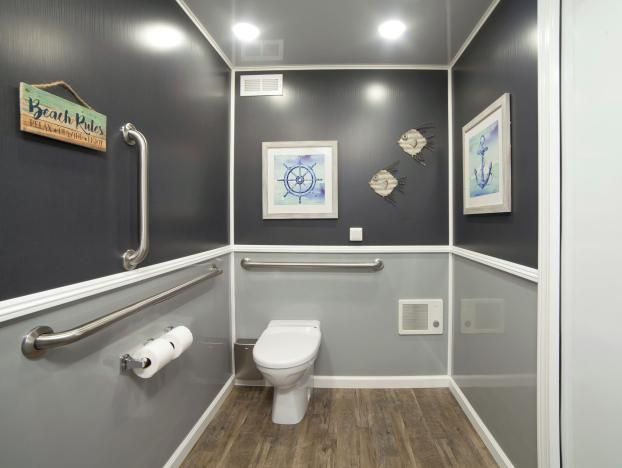 A portable bathroom with a toilet and a sign that says Beach Rules
