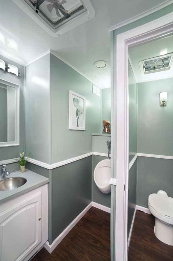 A portable bathroom with a sink, toilet  urinal and mirror