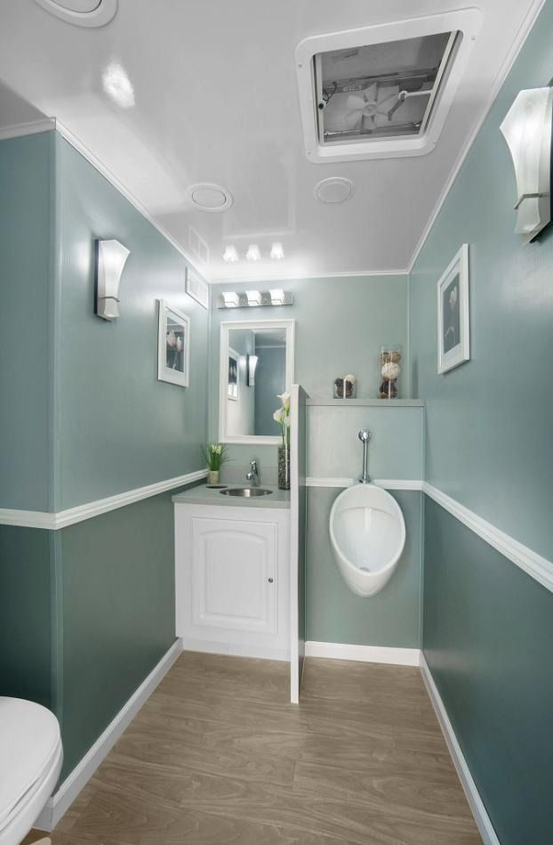 A portable bathroom with a toilet, sink and urinal