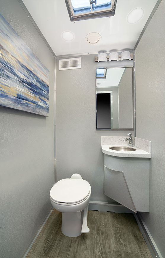 A bathroom with a toilet, sink and mirror