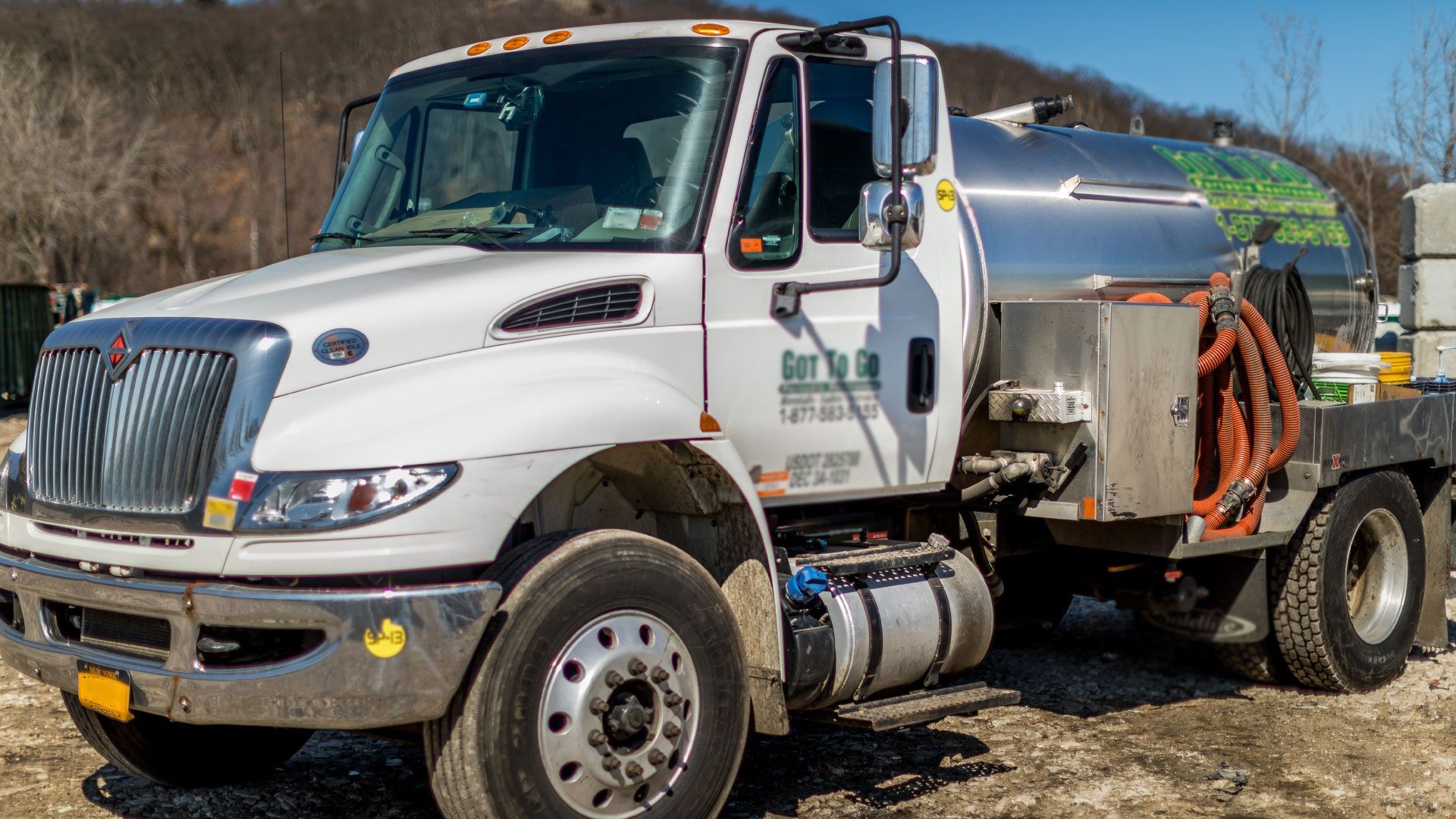 a large white truck is parked in a dirt field