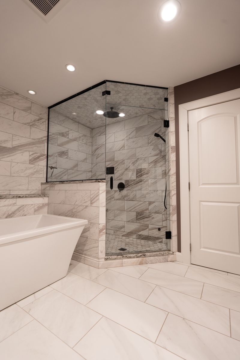 A bathroom with a tub and a walk in shower.