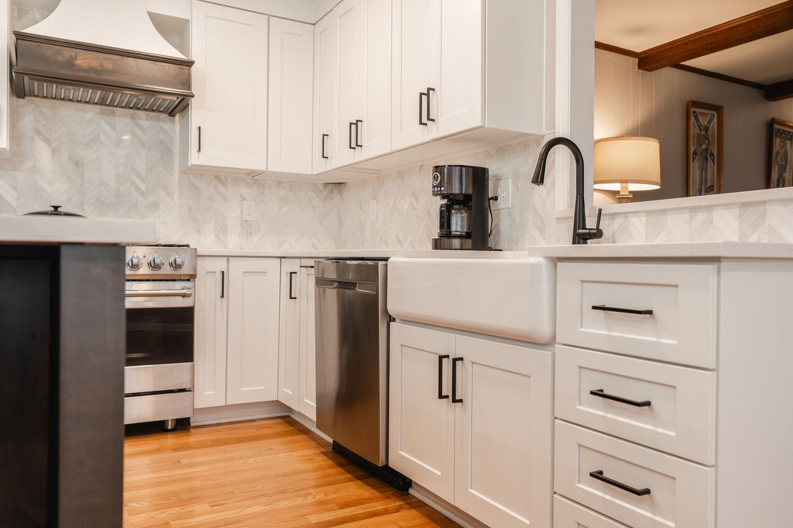 A kitchen with white cabinets , stainless steel appliances , and a farmhouse sink.