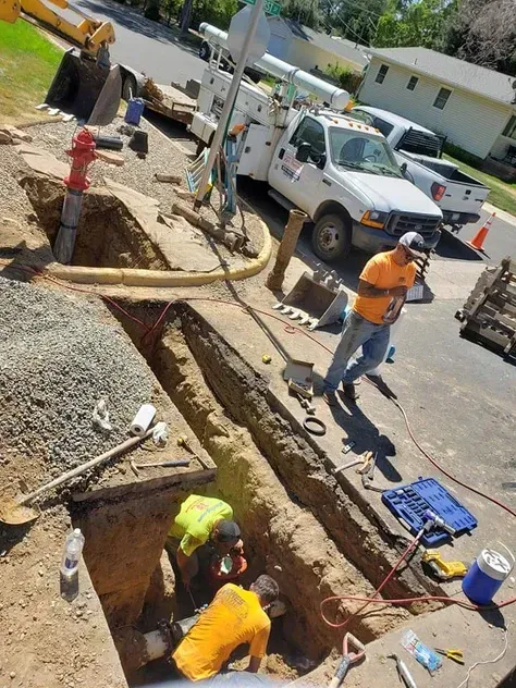 A group of construction workers are digging a hole in the ground.