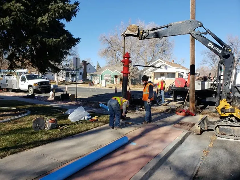 A deere excavator is being used to install a fire hydrant