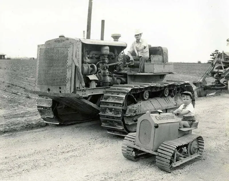 A black and white photo of a man driving a bulldozer