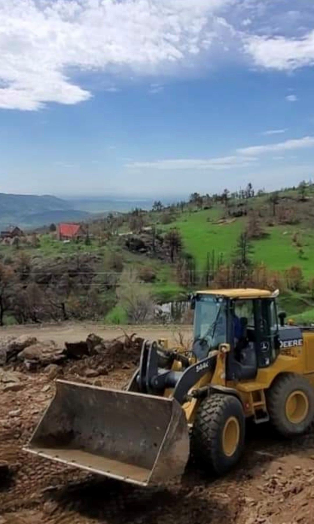 A bulldozer is sitting on top of a dirt hill.