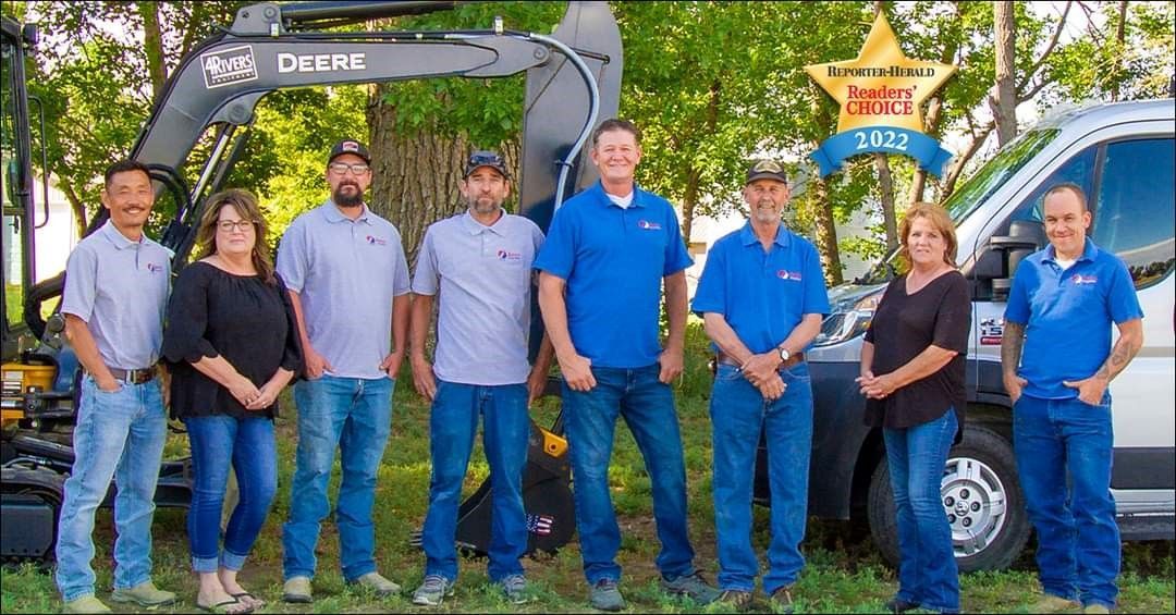 A group of people standing next to each other in front of a truck.