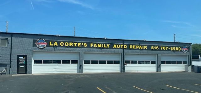 Exterior view of La Corte's Family Auto Repair shop, with three garage doors and a sign.