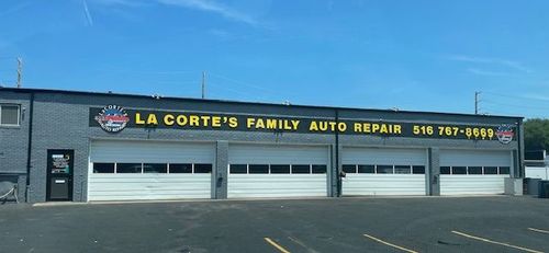 Exterior view of La Corte's Family Auto Repair shop, with three garage doors and a sign.