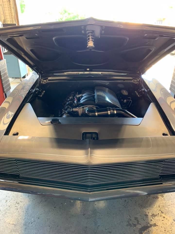 Gray classic car with hood open, showing the engine compartment and custom engine.