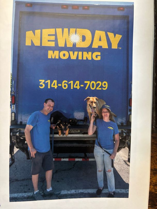 Two movers stand by a truck with a blue NEWDAY MOVING sign and phone number.