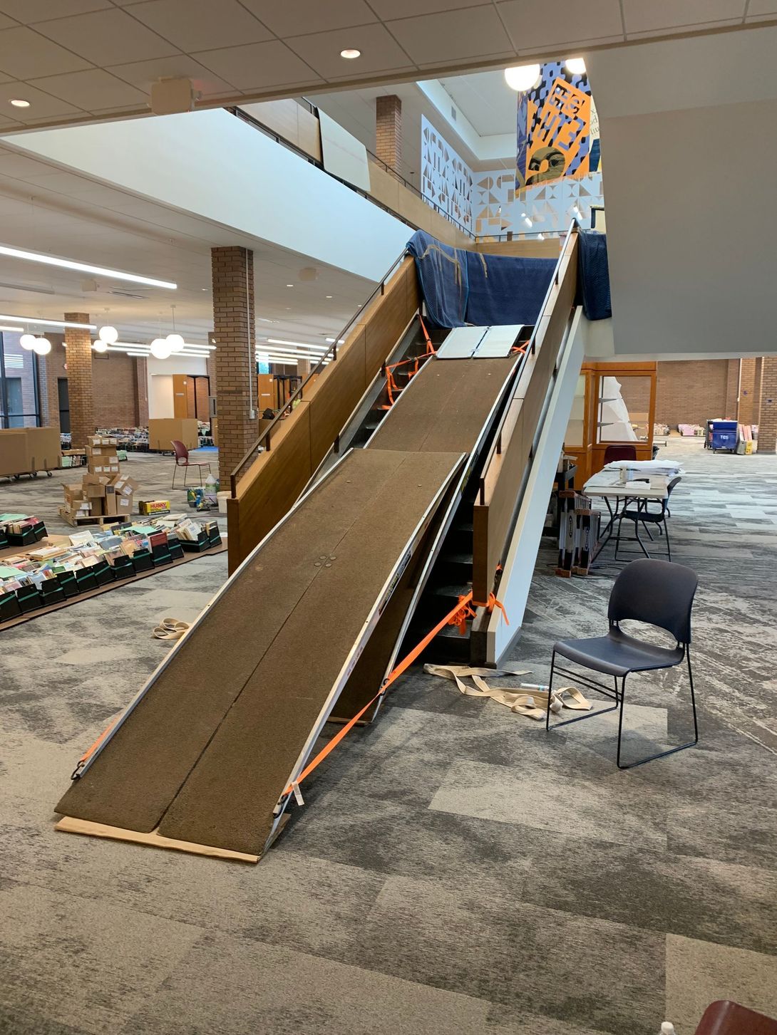 Indoor mall play area with a long indoor slide and a nearby seating area