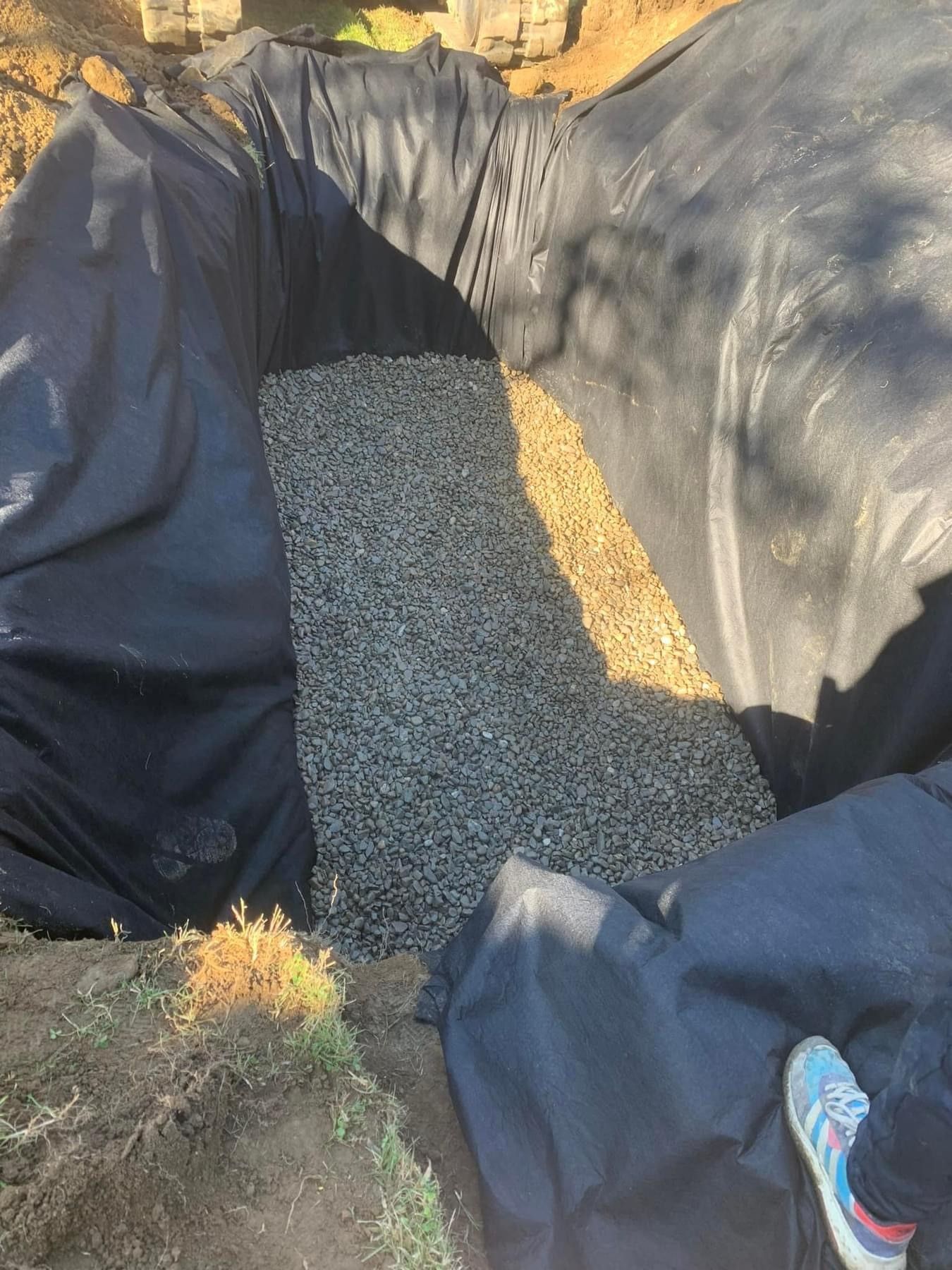 covering drainage tubes with liners and stones